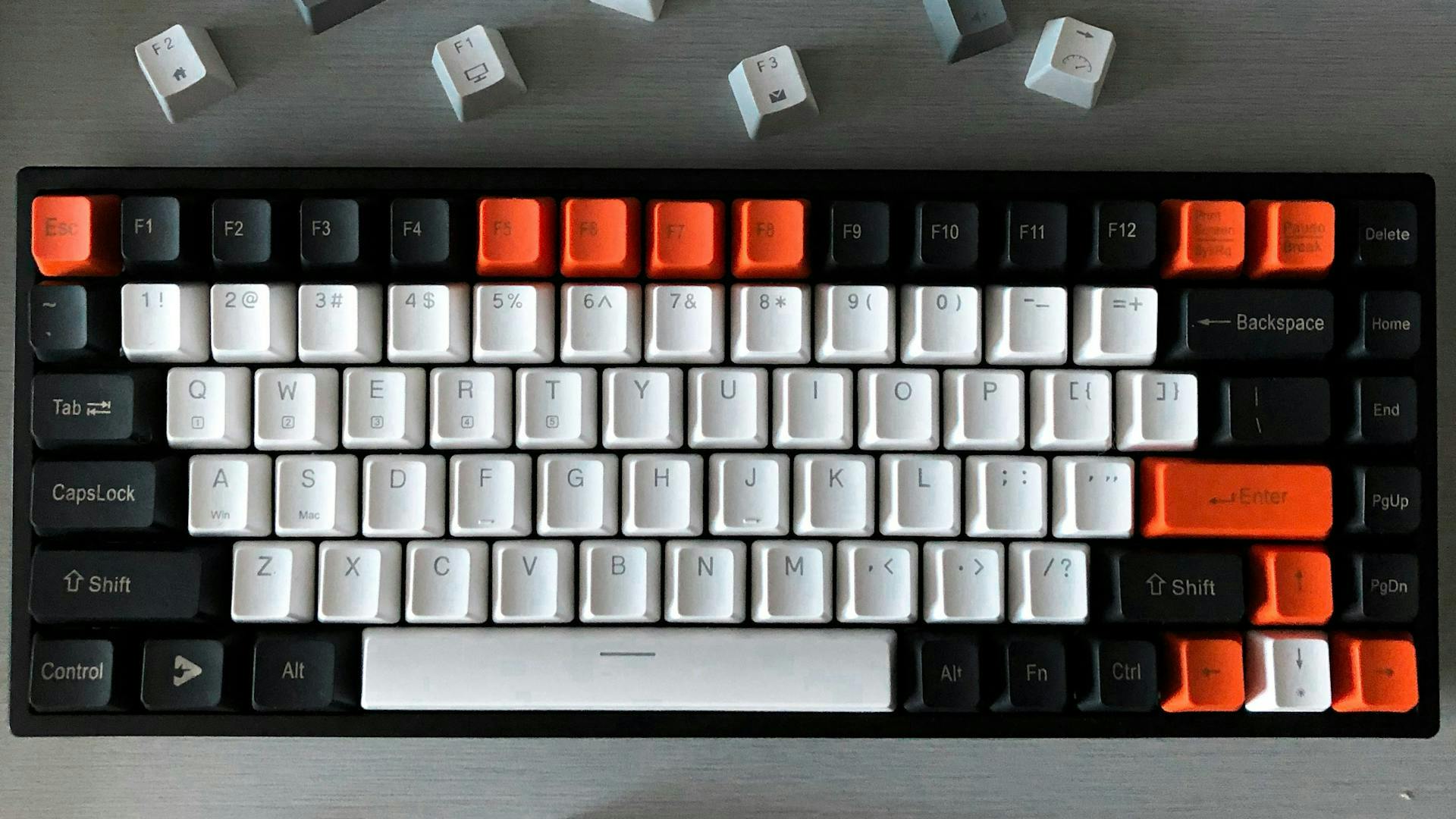 Eine Gaming Tastatur ohne Nummernblock aus der Vogelperspektive, auf der einige Tasten in schwarz, weiß und rot eingefärbt sind 