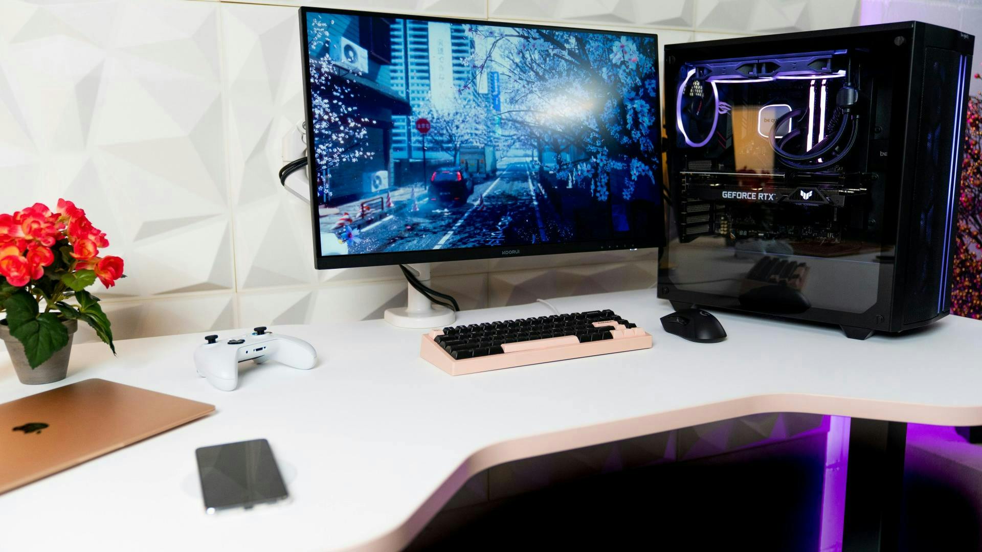 On an office-like, minimalist desk in dark wood tones, a laptop and keyboard stand in front of a TV monitor and speakers