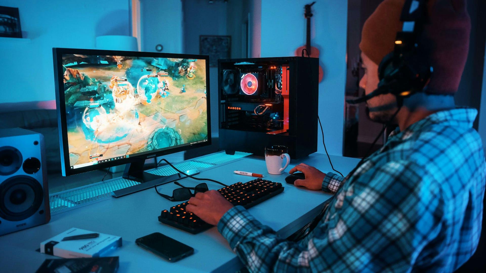 A gaming PC on a gaming table in a glowing pink LED setup